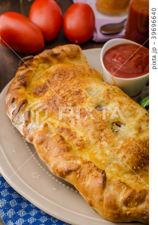 Calzone pizza stuffed with cheese and prosciutto 39696640