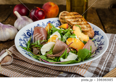 Rocket salad with prosciutto and fruit 39696985