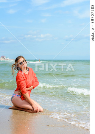 A beautiful woman in a red sweater sitting on the 39707288