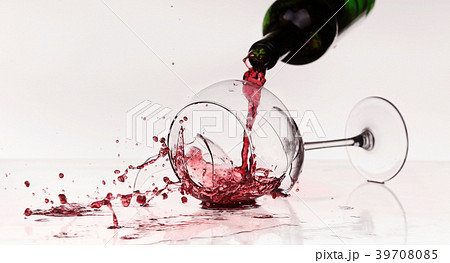 Broken wineglass on the table. Poured red wine Broken wineglass on the table. Poured red wine 39708085