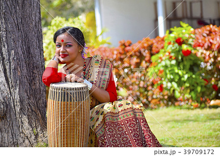 Assamese girl in traditional attire with dhol 39709172