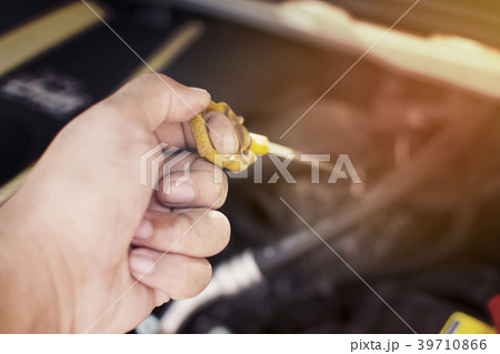 Hand of mechanic has checking oil engine level. Hand of mechanic has checking oil engine level. 39710866