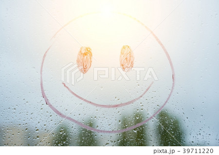 Positive funny smiley on a rainy autumn window 39711220