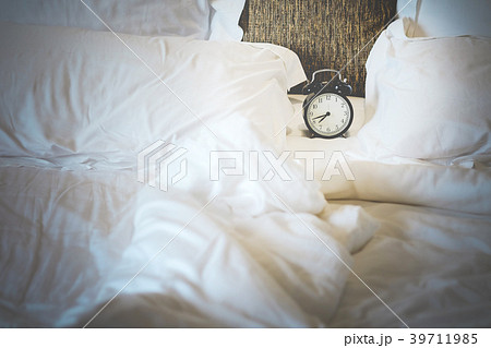 vintage black alarm clock at 8:00 am white bed. 39711985