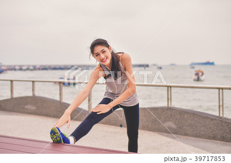 Sports concept. Beautiful girl is exercising on the beach with w 39717853