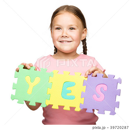 Cute little girl is holding Yes slogan 39720287