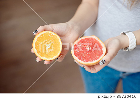 Orange and grapefruit in human's hands. 39720416