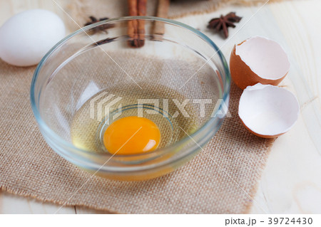 Egg on clear glass bowl over wooden cut board 39724430