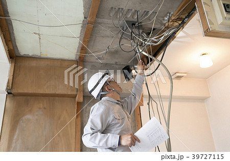 マンション・スケルトンリフォーム・電気工事・図面を持ちながらチェックする作業員 39727115