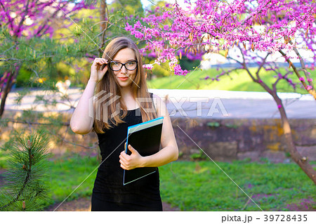 Female student touching glasses in garden and 39728435