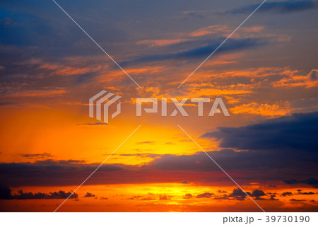 Cloudy sky and bright sun rise over the horizon. 39730190