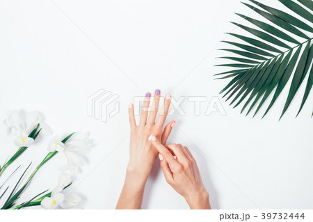 Woman applying hand cream among tropical flowers 39732444