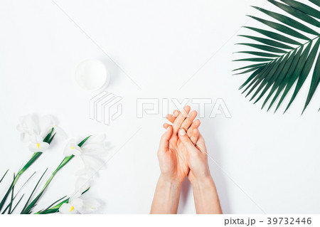 Woman applying hand cream among tropical flowers 39732446
