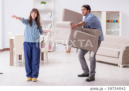 Man moving armchair in the living room 39734042