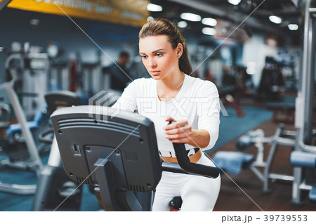 Indoor cycling woman doing cardio workout biking Indoor cycling woman doing cardio workout biking 39739553