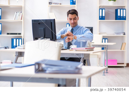 Handsome businessman employee sitting at his desk Handsome businessman employee sitting at his desk 39740054