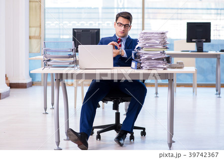 Businessman workaholic struggling with pile of Businessman workaholic struggling with pile of 39742367