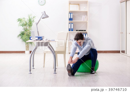 Employee exercising with swiss ball during lunch 39746710