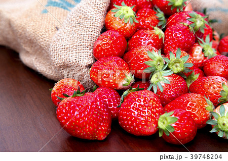 麻袋から溢れる沢山の新鮮なイチゴ 39748204