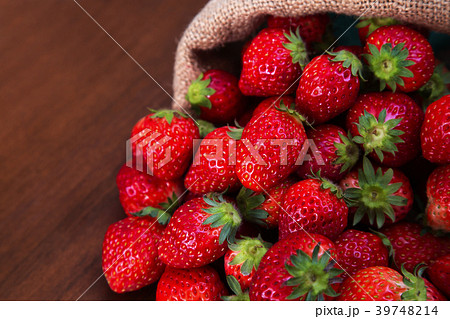 麻袋から溢れる沢山の新鮮なイチゴ 39748214