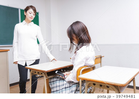 授業中にスマホを使う学生と注意する教師 39749481