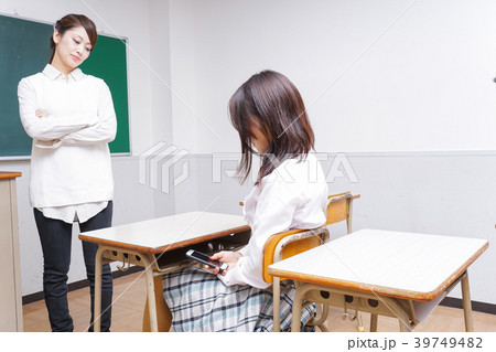 授業中にスマホを使う学生と注意する教師 39749482