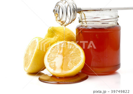 A glass of honey with dipper and lemon 39749822