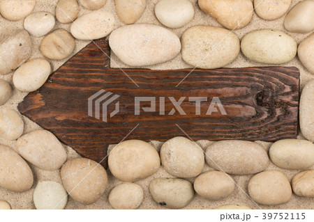 Classical wooden arrow and white stones on  sand. 39752115