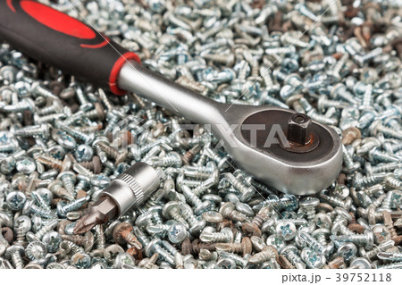 Screwdriver lying on a pile of screws. Screwdriver lying on a pile of screws. 39752118