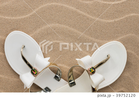 White flip flops on the sand of the beach. White flip flops on the sand of the beach. 39752120