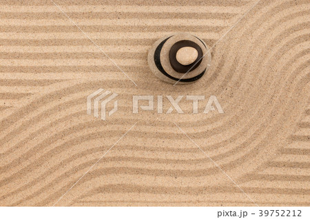 Pyramid made of stones standing on  striped sand. 39752212