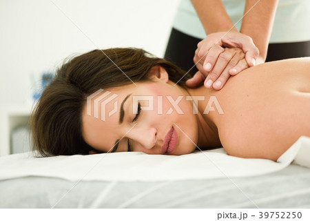 Young woman receiving a back massage in a spa center. Young woman receiving a back massage in a spa center. 39752250