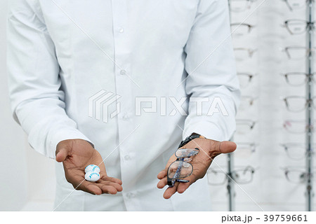 Man in white shirt is keeping optical eyeglasses. 39759661
