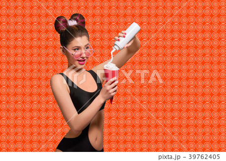 Pop art model pressing cream into red horn. 39762405