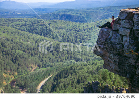 Young man hiker sitting on top of a mountain on on Young man hiker sitting on top of a mountain on on 39764690