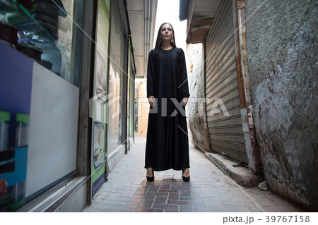 Beautiful woman in abaya walking through the 39767158
