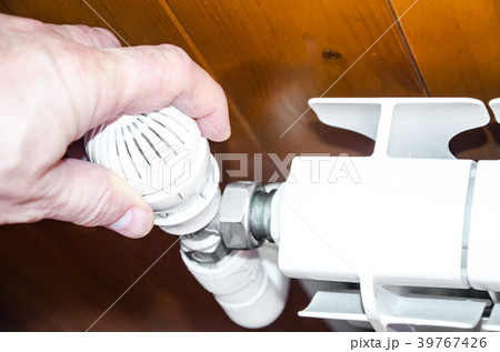 Hand regulates temperature in radiator 39767426
