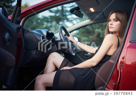 Beautiful serious girl sit in car with one leg out Beautiful serious girl sit in car with one leg out 39770843