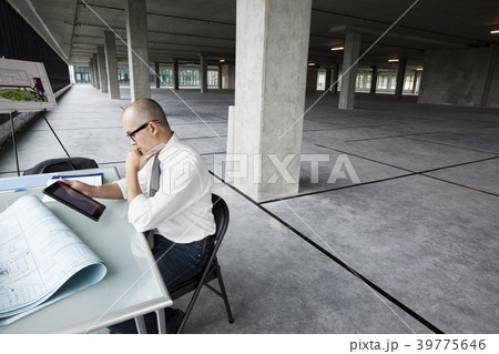 Asian architect Woking on workspaces in a new raw office location. 39775646
