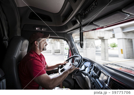 Interior cab view of a Caucasian man driving his  commercial truck. 39775706