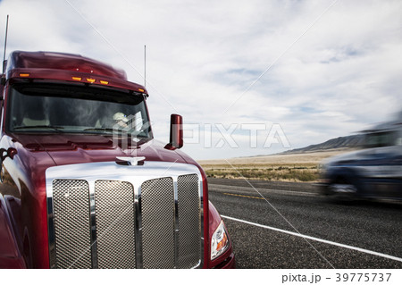 Partial view of the cab on a  commercial truck and the highway. 39775737