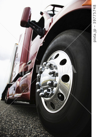 The cab and front tire on a  commercial truck on the road at sunset. 39775748