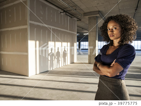 Black businesswoman  standing in an empty raw office space. 39775775