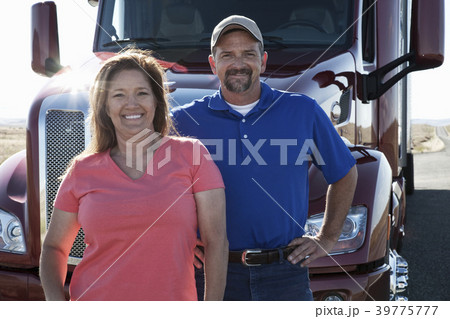 Portrait of a Caucasian husband and wife driving team with their  commercial truck. 39775777