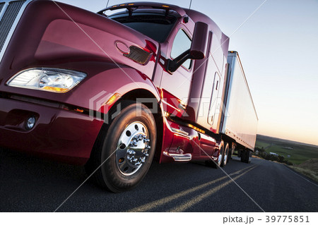 Front to rear low angle view of  the cab of a  commercial truck on the highway late in the day. 39775851