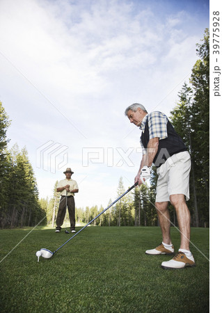 Senior golfer teeing off during a round of golf. Senior golfer teeing off during a round of golf. 39775928