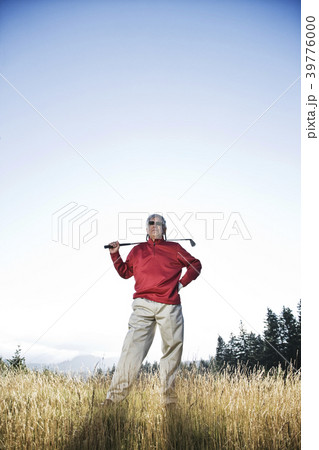 Senior golfer standing in heavy rough pondering his next shot. Senior golfer standing in heavy rough pondering his next shot. 39776000