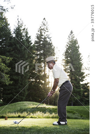 Senior golfer teeing off during a round of golf. 39776015