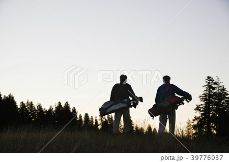 Two seniors walking down the fairway toward the next golf green. Two seniors walking down the fairway toward the next golf green. 39776037
