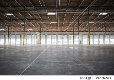 Wide angle interior view of large empty warehouse and loading dock doors 39776283